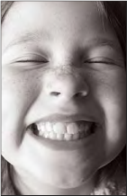 A close up of a child smiling widely