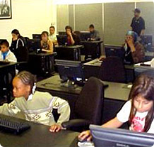 Children and adults at computer stations at the Community Development Technologies Center