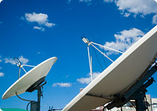 Satellite Dishes under a blue sky with small clouds in the background