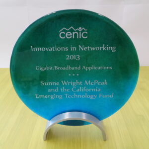 Photo of a circular glass award. The award is for the 2013 CENIC Innocations in Networking Gigabit/Broadband Applications - Sunne Wright McPeak and CETF